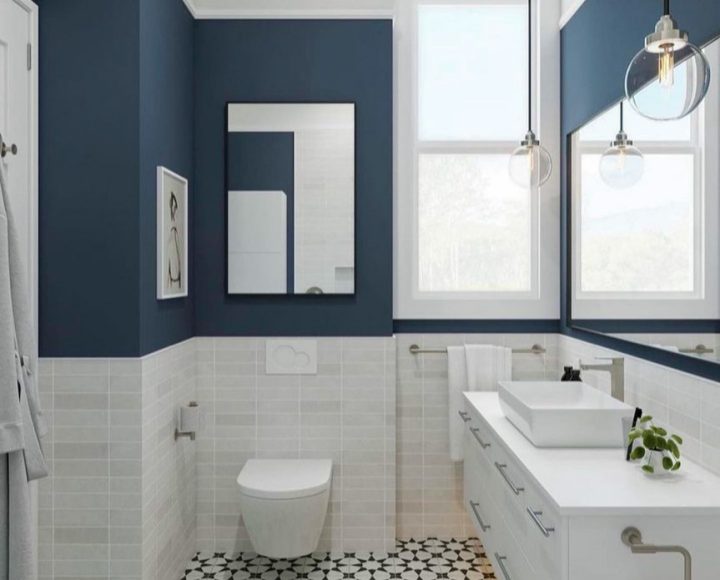 A compact bathroom with tile flooring and wall, a toilet mounted on the wall, and a storage cabinet with sink on top