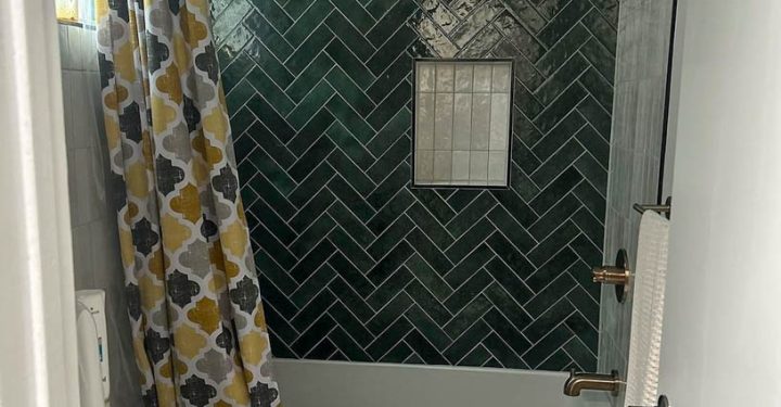 Walls installed with tiles for shower backsplash, a bathtub, and a toilet